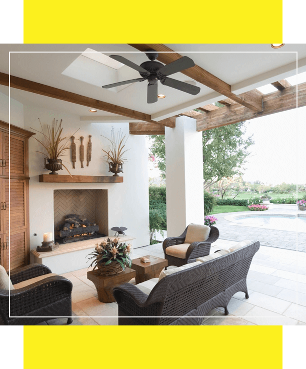 Outdoor patio with wicker furniture and ceiling fan.